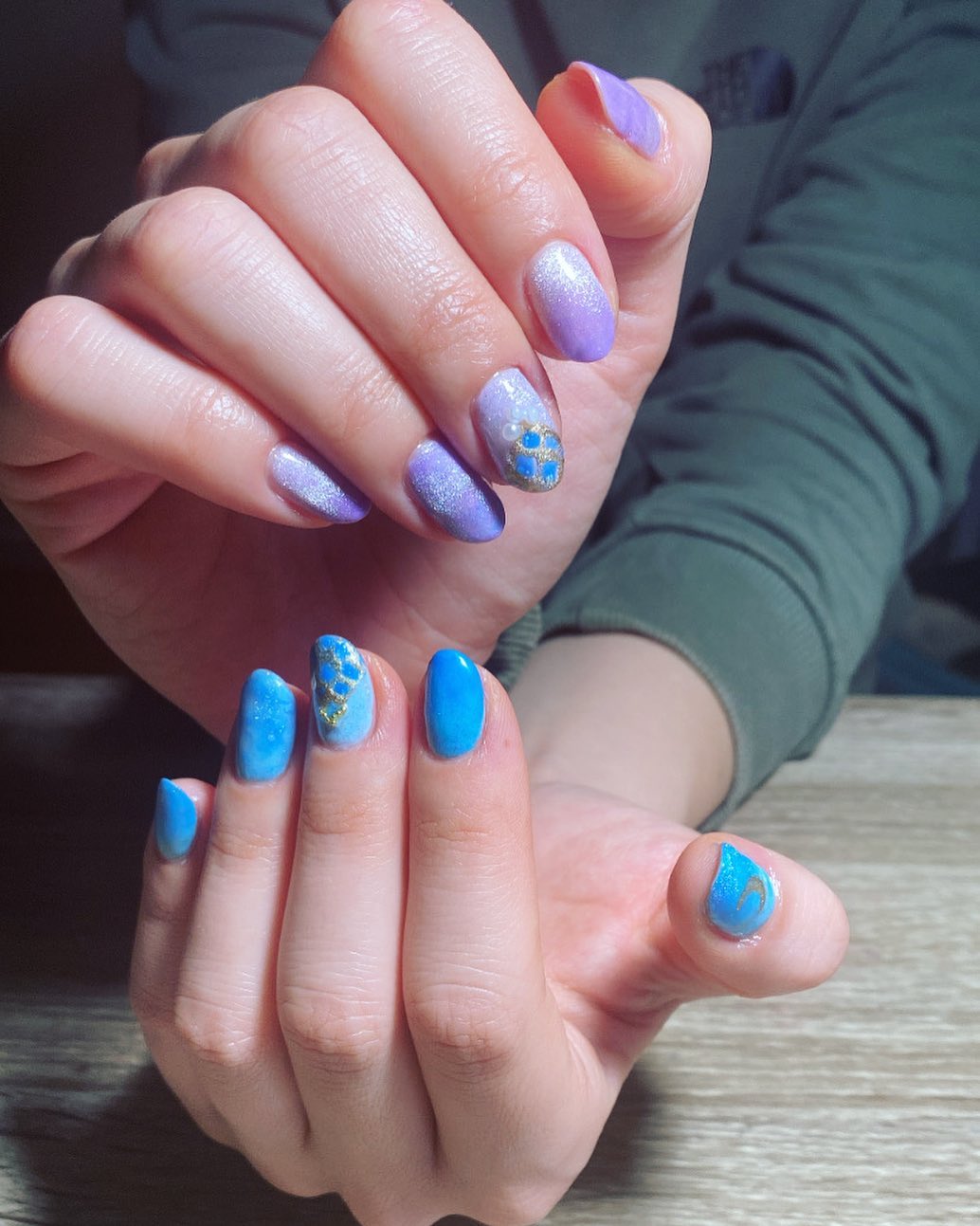 Couleurs d’ongles violettes et bleues scintillantes avec un design d’ongle minimaliste sur des ongles ronds courts