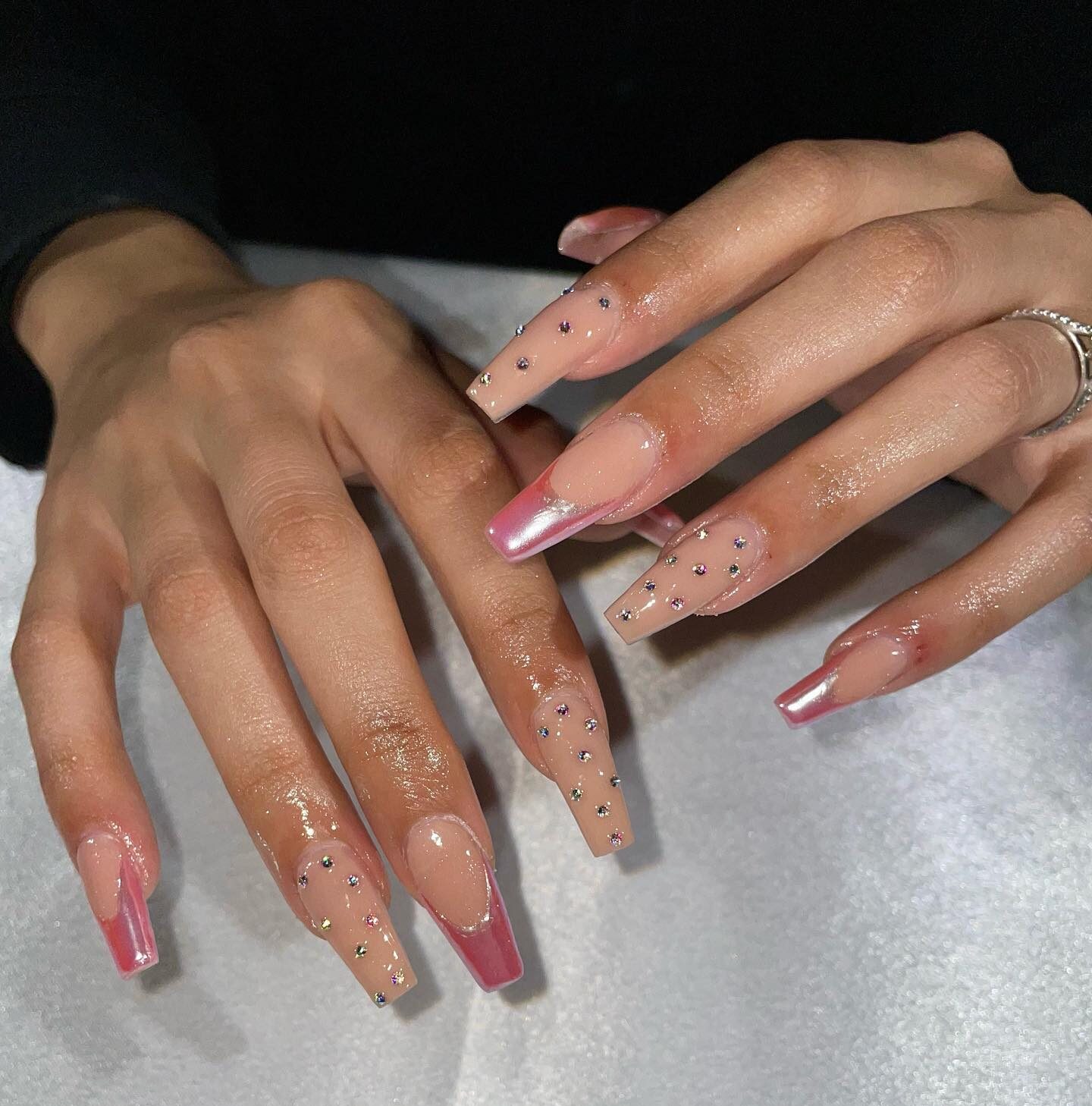 Ongles en acrylique en forme de cercueil de couleur nude avec pointes françaises rose chrome et strass