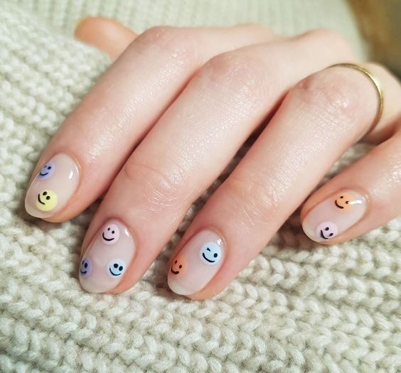 Smileys multicolores sur les ongles ronds courts