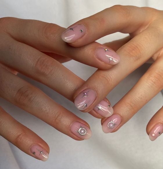 Ongles ronds courts et clairs avec signe Taureau et éléments célestes nail arts