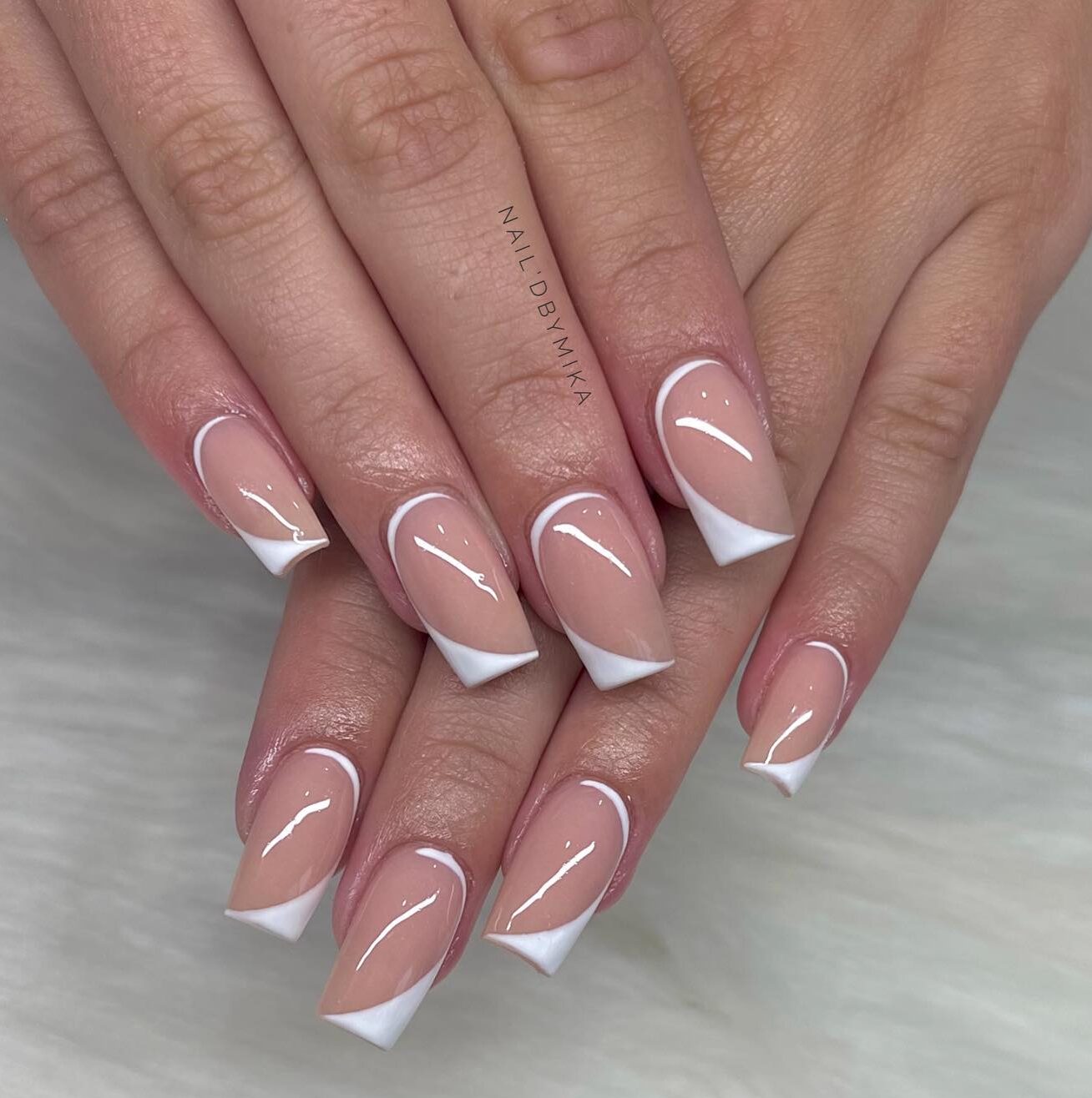 Vernis à ongles de couleur neutre avec nail art abstrait blanc sur ongles carrés effilés moyens