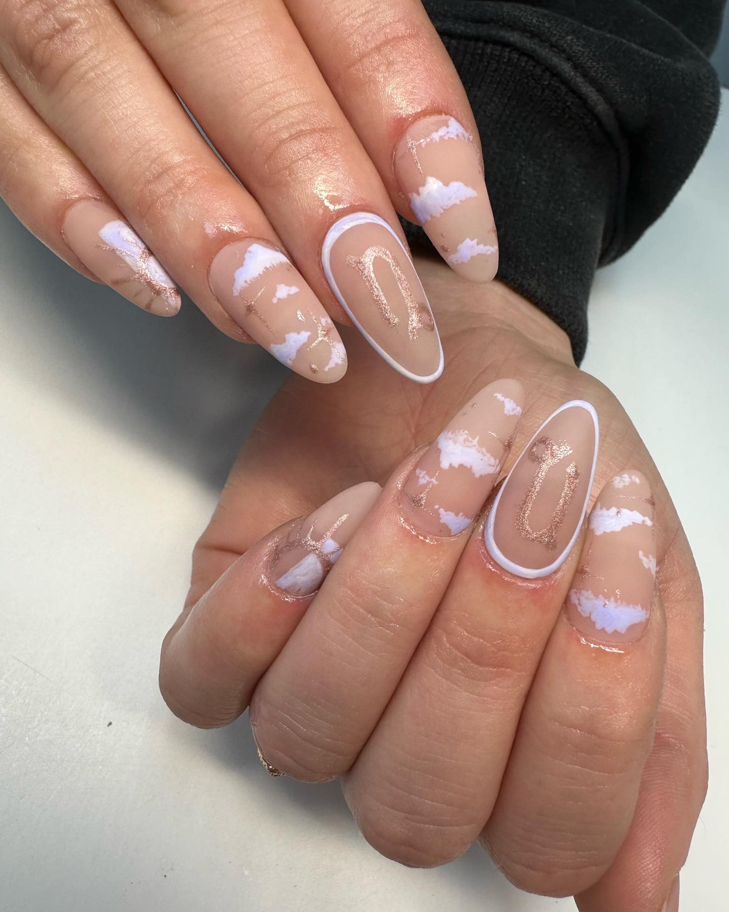 Vernis à ongles nude au fini mat avec des motifs d’ongles d’éléments célestes sur de longs ongles en amande