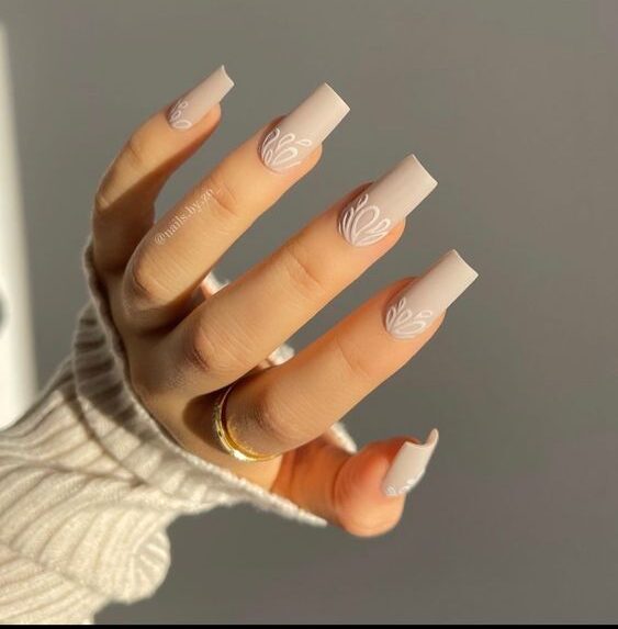 Vernis à ongles beige finition mate avec nail art abstrait sur ongles longs carrés