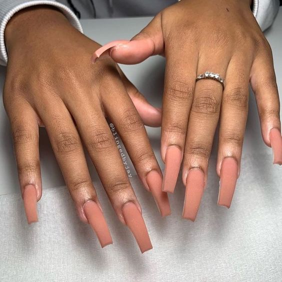 Couleur d’ongle nude au fini mat simple et uni sur ongles acryliques carrés longs et effilés