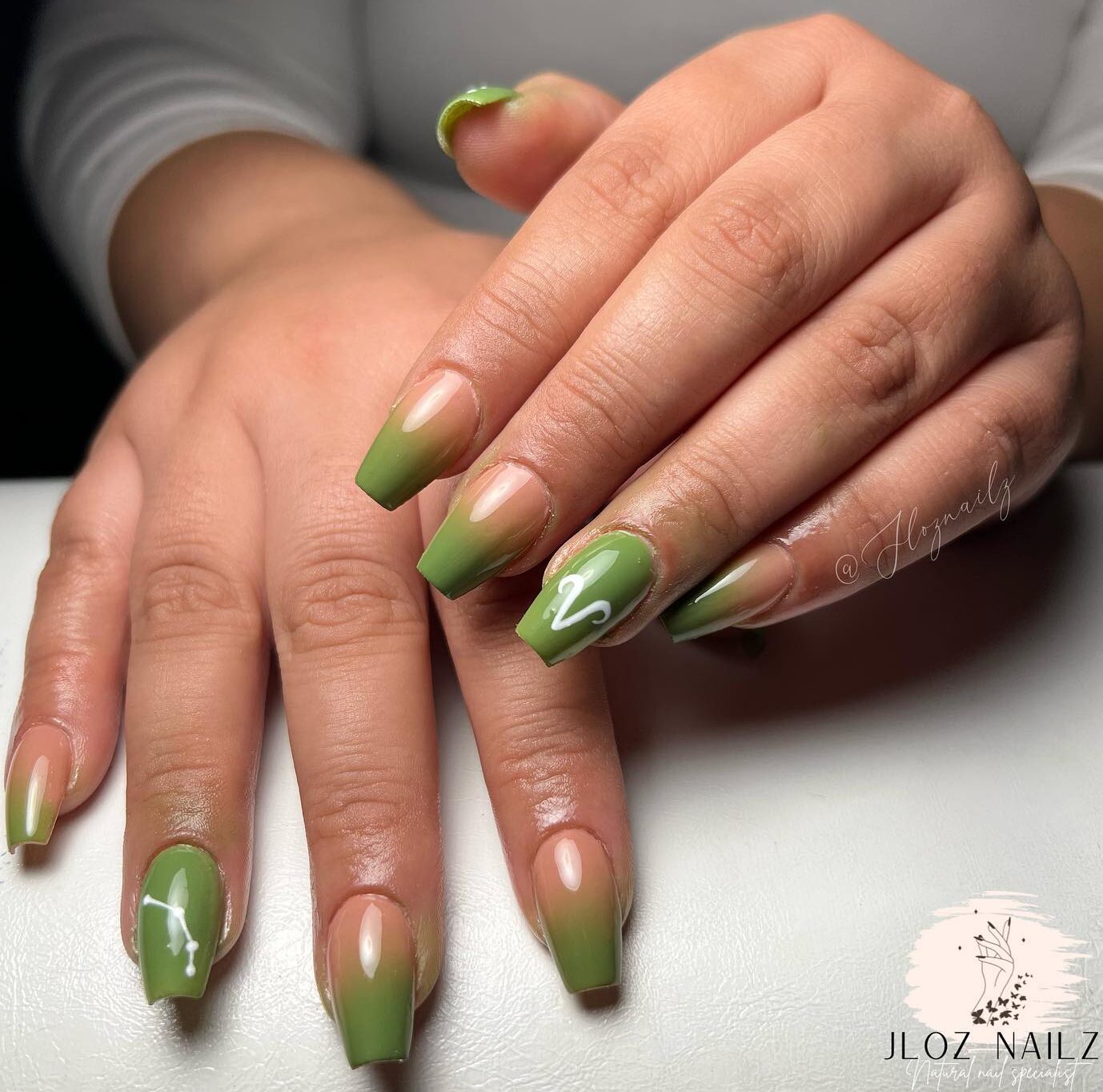 Effet ombré nu à vert clair avec signe Bélier et motifs d’ongles constellation sur des ongles de cercueil moyens