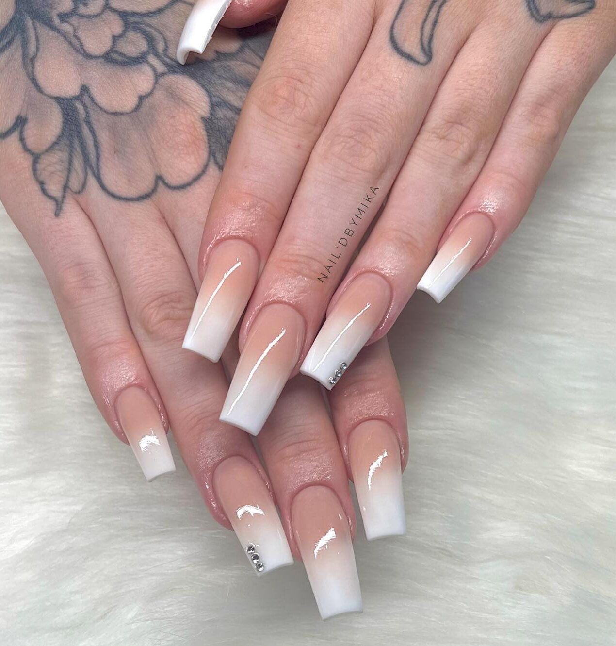 Nail art effet nude à blanc ombré avec des pierres sur de longs ongles carrés effilés en acrylique