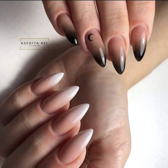 Effet ombré nude à noir avec nail art lune en finition brillante sur les ongles longs en amande