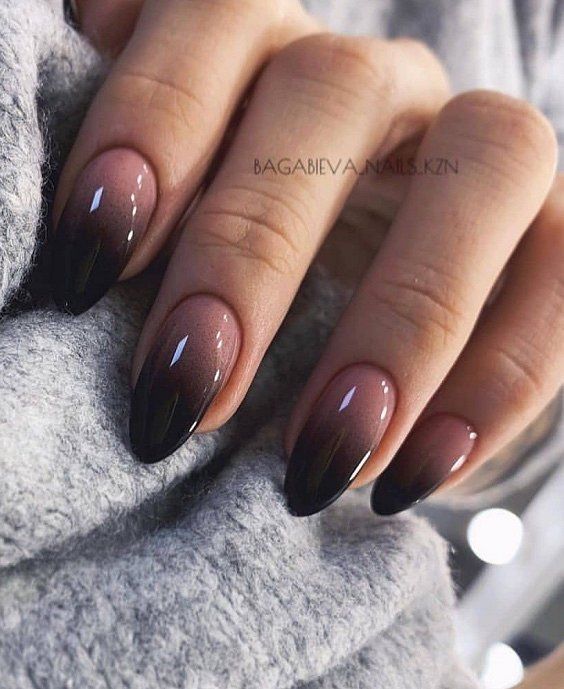 Nail art à effet ombré nude à noir audacieux en finition brillante sur les ongles en amande moyenne