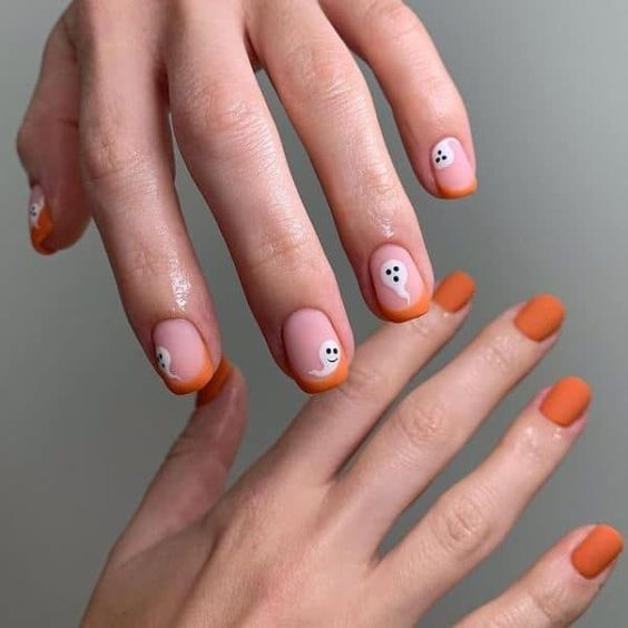 Ongle de couleur orange finition mate vernis et pointes françaises orange avec fantômes nail art sur ongles carrés courts effilés