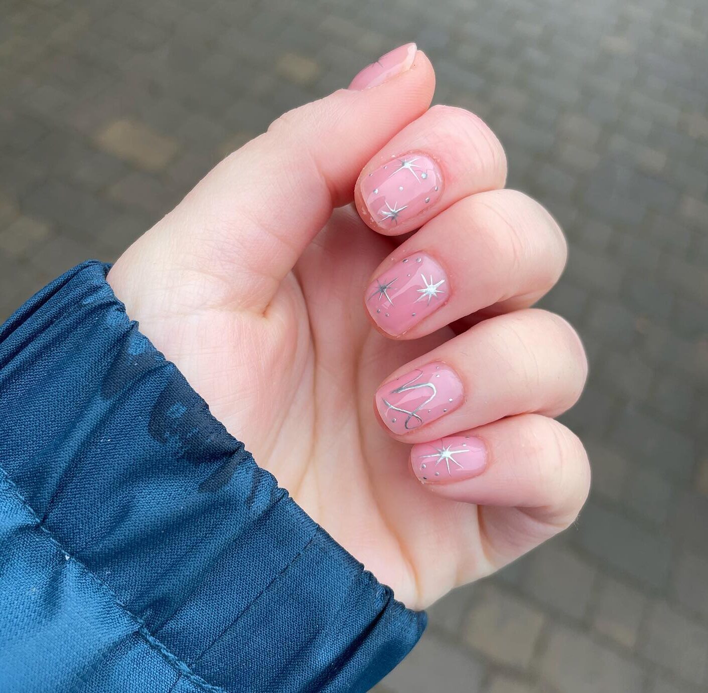 Ongles naturels rosés avec symbole Capricorne et motifs d’ongles d’éléments célestes