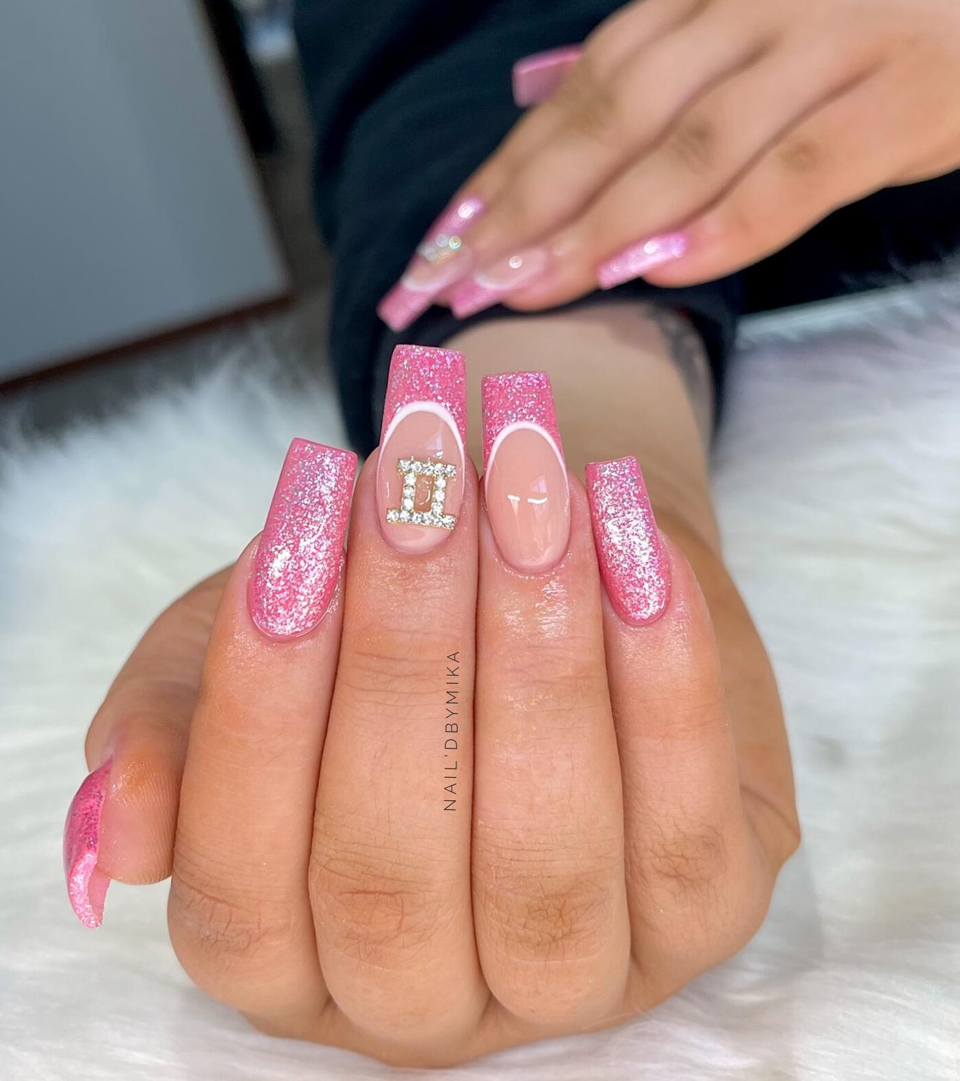 Ongles longs et effilés en acrylique de forme carrée avec des paillettes roses, des pointes françaises et des motifs d’ongles bling 3D