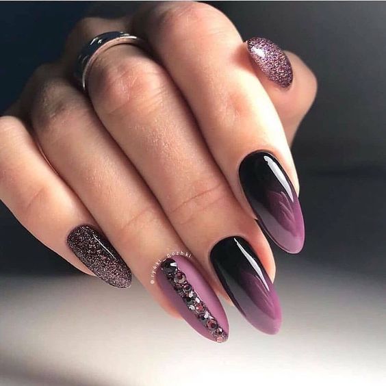 Nail art ombré prune brillant avec des paillettes et des strass sur de longs ongles en amande