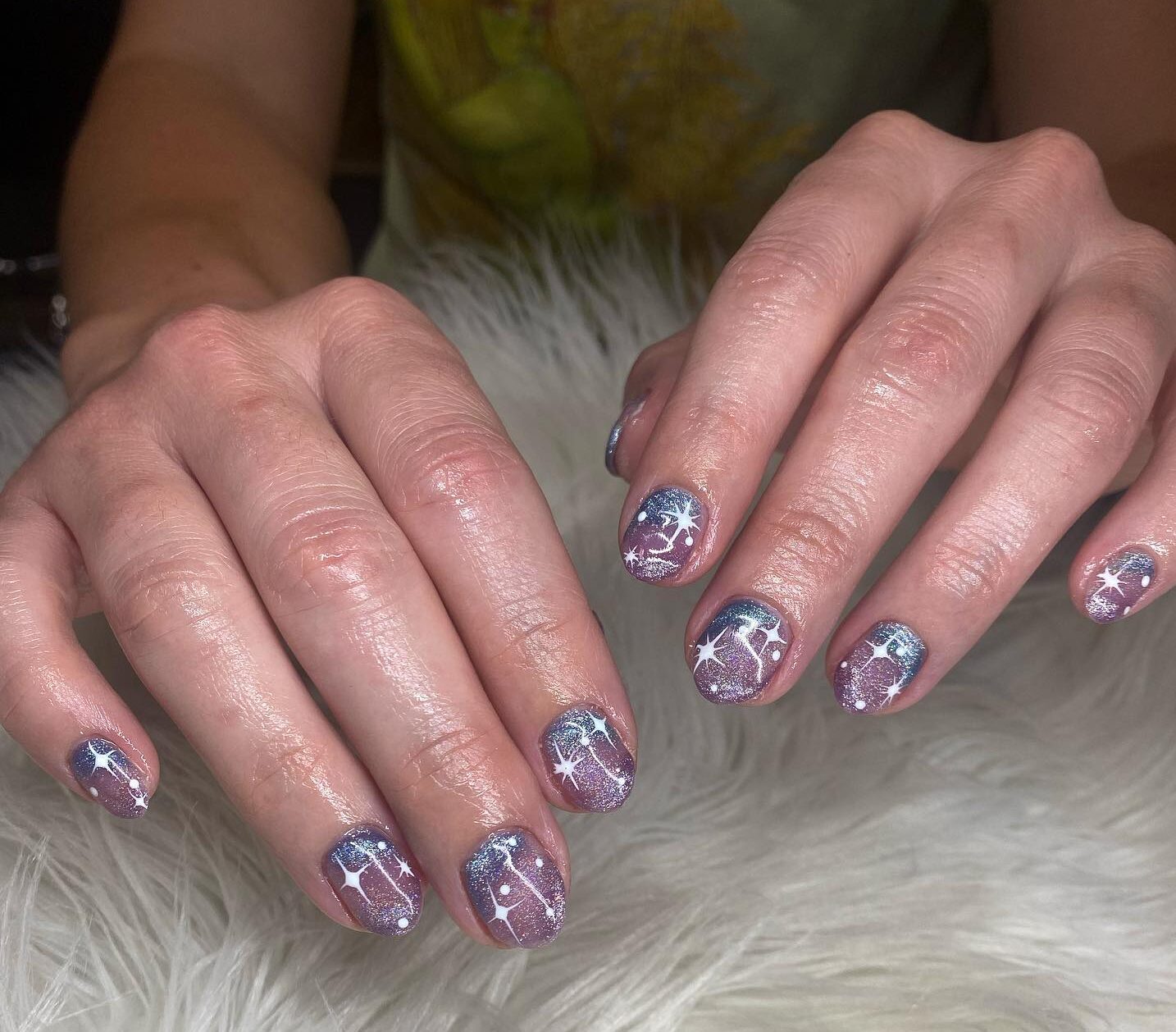 Couleur d’ongle violette scintillante avec des éléments célestes nail art sur ongles ronds courts