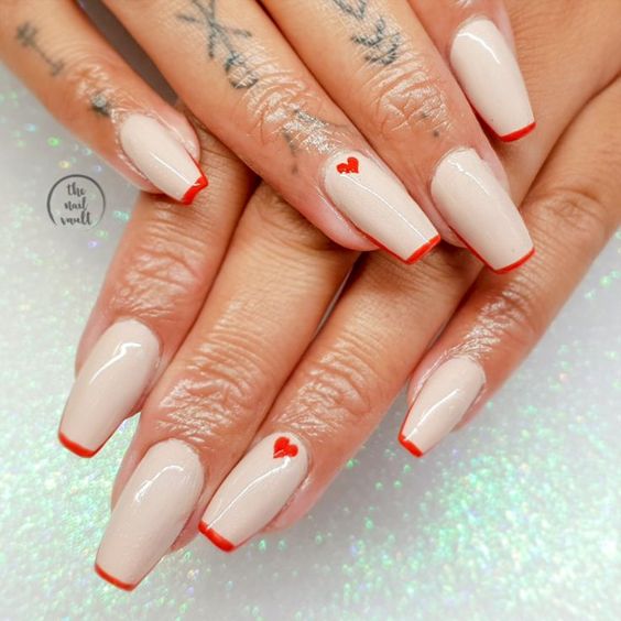 Vernis à ongles de couleur crème avec nuance rouge, pointes françaises fines et coeurs rouges, nail art sur ongles cercueil moyens