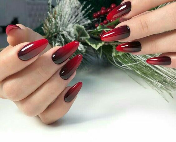 Finition brillante : design d’ongles à effet ombré rouge profond sur les ongles longs en amande