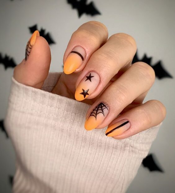 Effet ombré orange avec des nail arts inspirés d’Halloween sur des ongles ronds courts