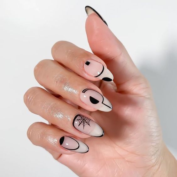 Nail art abstrait noir et conception d’ongles en toile d’araignée sur de longs ongles ronds translucides