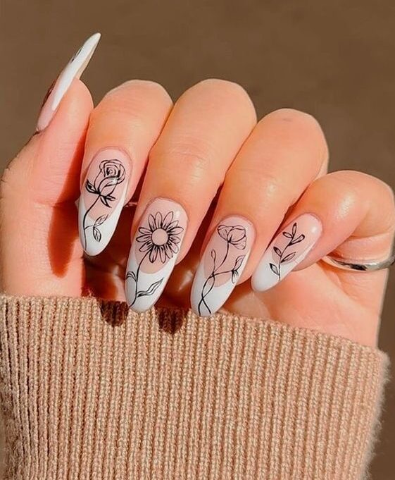 Pointes françaises blanches avec des nail arts floraux sur de longs ongles ronds en acrylique