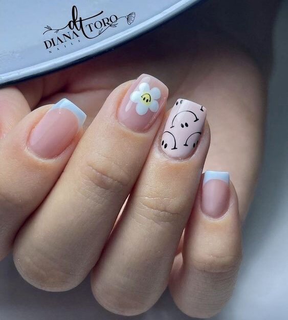 Smileys, nail art fleur blanche, et pointes françaises bleu clair sur ongles courts et carrés