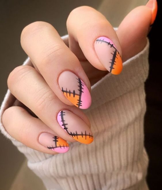 Motifs abstraits roses et oranges avec des points de couture nail art sur ongles ronds moyens