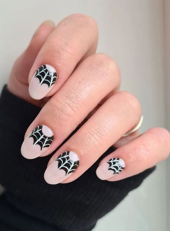 Vernis à ongles blanc pâle avec nail art en toile d’araignée sur ongles ronds courts