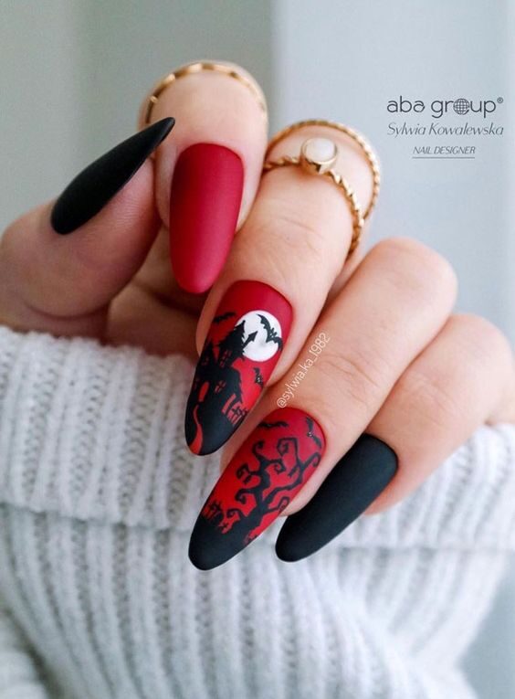 Vernis à ongles noir et rouge avec un design d’ongle effrayant de maison hantée sur de longs ongles en amande