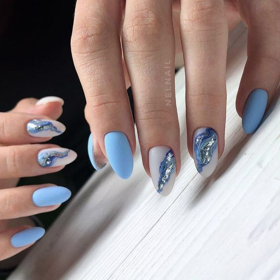 Vernis à ongles bleu et blanc électrique au fini mat avec nail art marbré sur ongles en amande moyenne