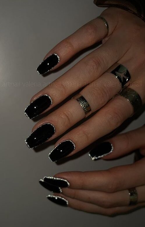 Couleur d’ongle noire brillante avec des contours argentés sur les ongles carrés moyens