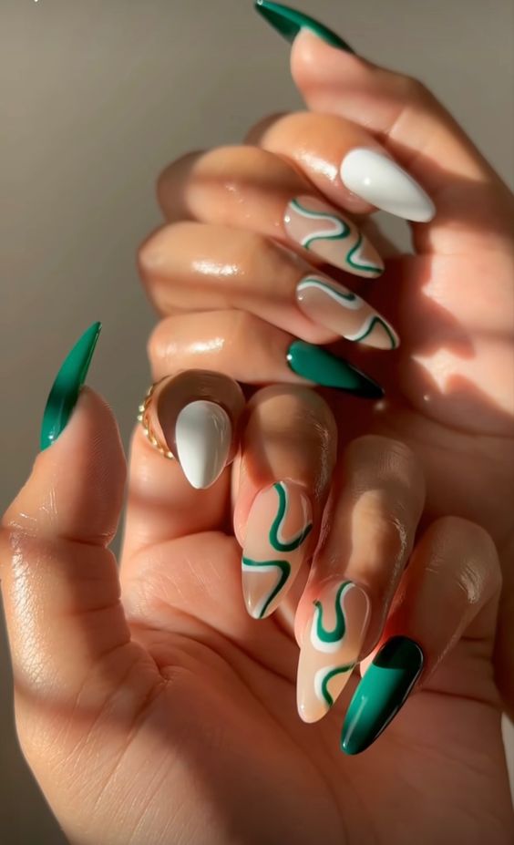 Combinaison verte et blanche de vernis à ongles sur les ongles en amande