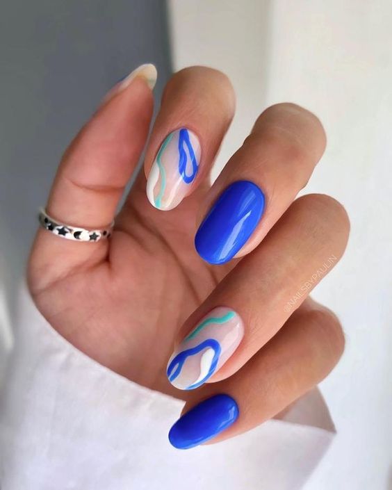 Vernis à ongles bleu vif et tourbillons bleus conception d’ongles sur de longs ongles ronds