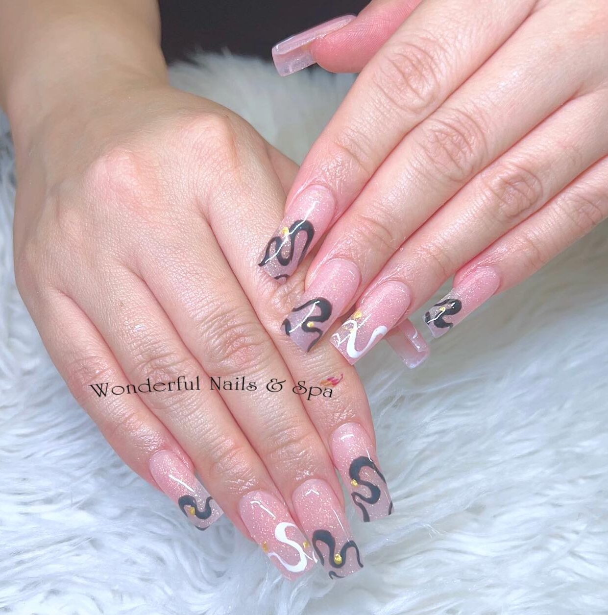 Longs ongles carrés effilés en acrylique transparent avec des motifs d’ongles tourbillonnant noir et blanc