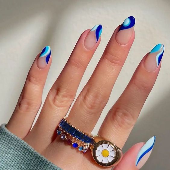 Ongles en acrylique clairs de forme ronde moyenne avec des nuances de tourbillons bleus