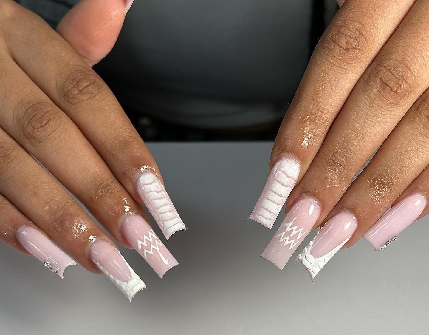 Ongles en acrylique de forme carrée longue et blanche pâle avec imprimé crocodile blanc et motifs d’ongles du signe du Verseau