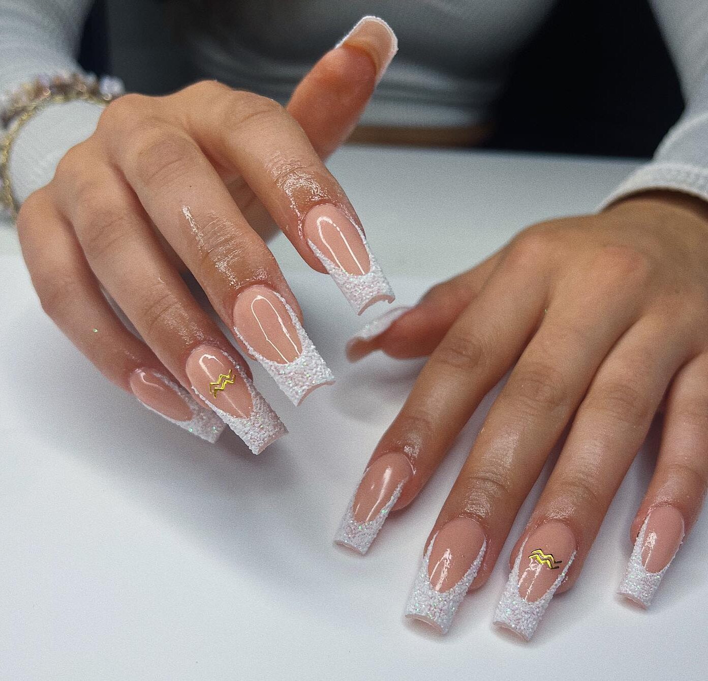 Pointes Françaises blanches et Verseau doré signe nail arts sur ongles longs carrés