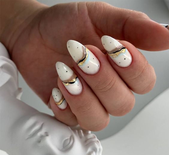 Couleur d’ongle blanc sale avec de minuscules points et des nail arts élégants sur de longs ongles ronds