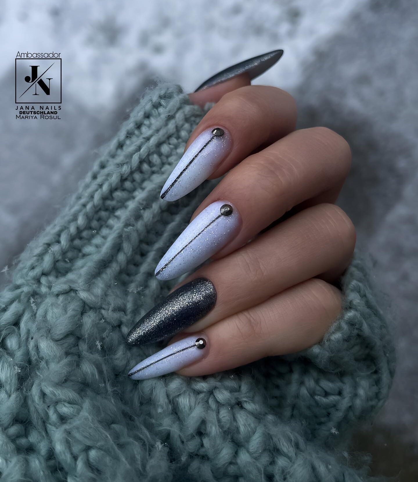 Vernis à ongles blanc et gris scintillant avec des lignes nettes sur de longs ongles en amande