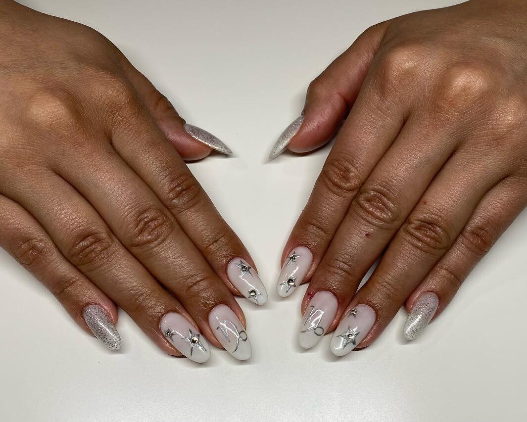 Couleur des ongles blanche avec symbole du Capricorne et éléments célestes sur de longs ongles ronds