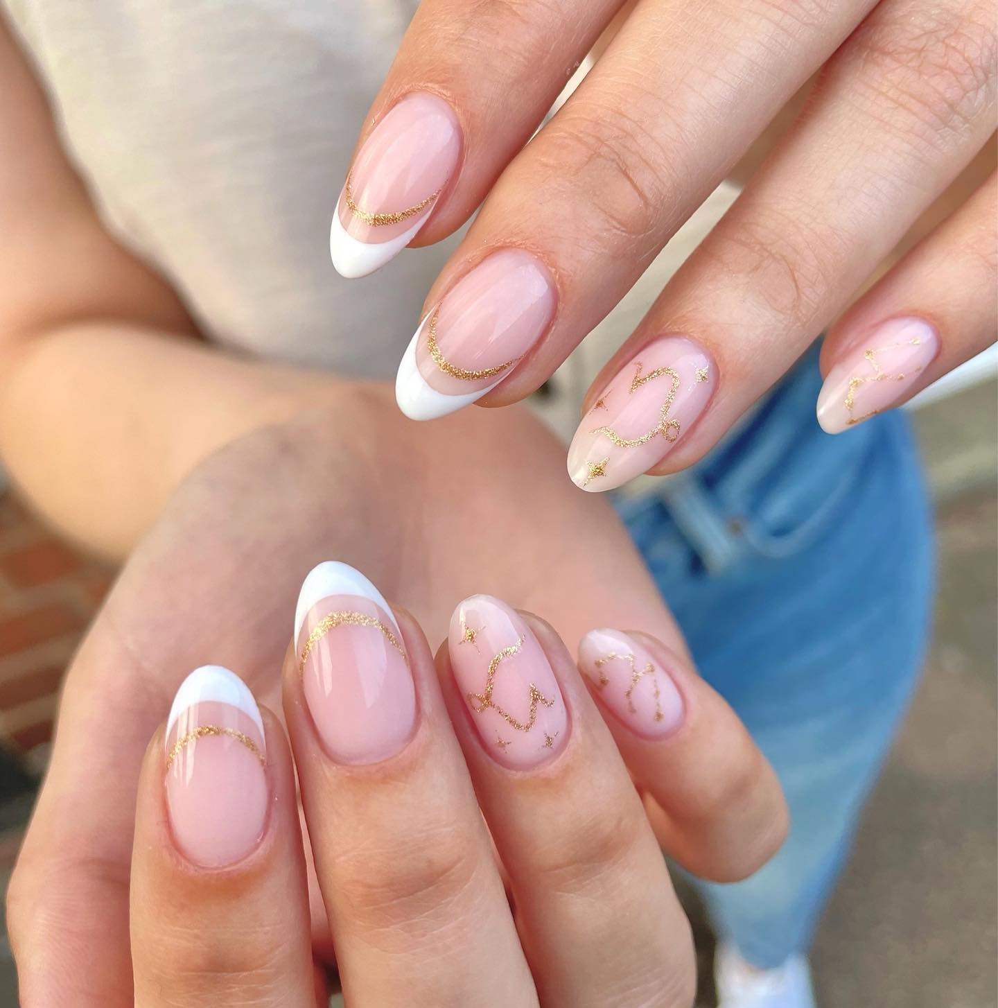 Combinaison de pointes françaises blanches et de motifs d’ongles dorés symbole du Capricorne et constellation sur des ongles ronds moyens