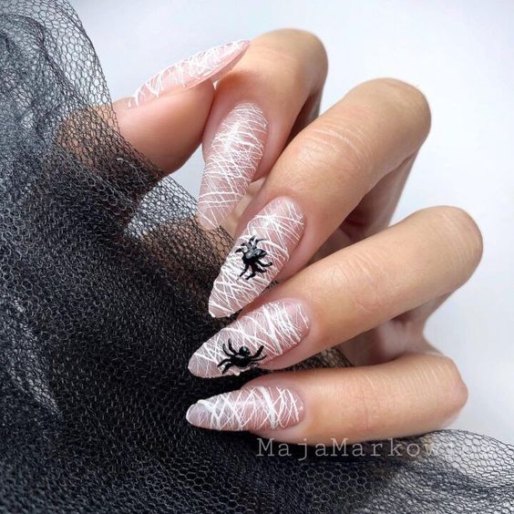 Toiles d’araignée blanches et nail arts d’araignée noire sur de longs ongles en amande