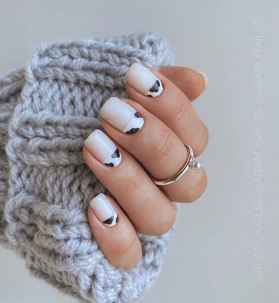 Vernis à ongles blanc avec nail art imprimé vache sur ongles carrés courts et effilés