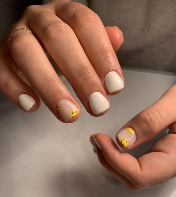 Vernis à ongles blanc et smiley jaunes nail art sur ongles carrés courts