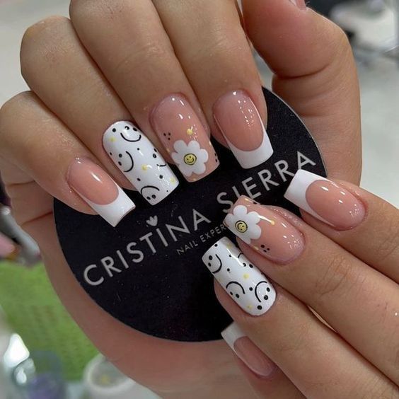 Couleur d’ongles blanche avec smileys noirs et nail art fleur blanche sur ongles carrés moyens