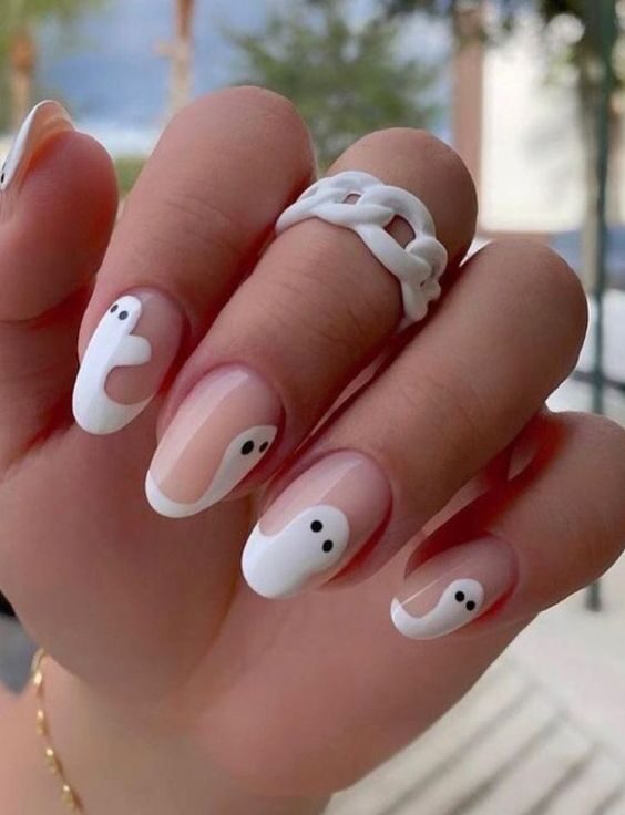 Ongles courts ronds et clairs avec des motifs d’ongles fantômes sur les pointes