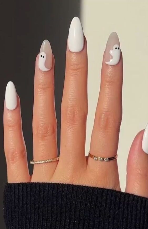 Vernis à ongles blancs et dessins d’ongles fantômes sur de longs ongles translucides en forme d’amande