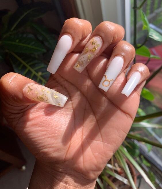 Nail art de couleur d’ongle blanc et marbre blanc avec feuille d’or et signe Taureau doré sur de longs ongles acryliques effilés en forme de carré