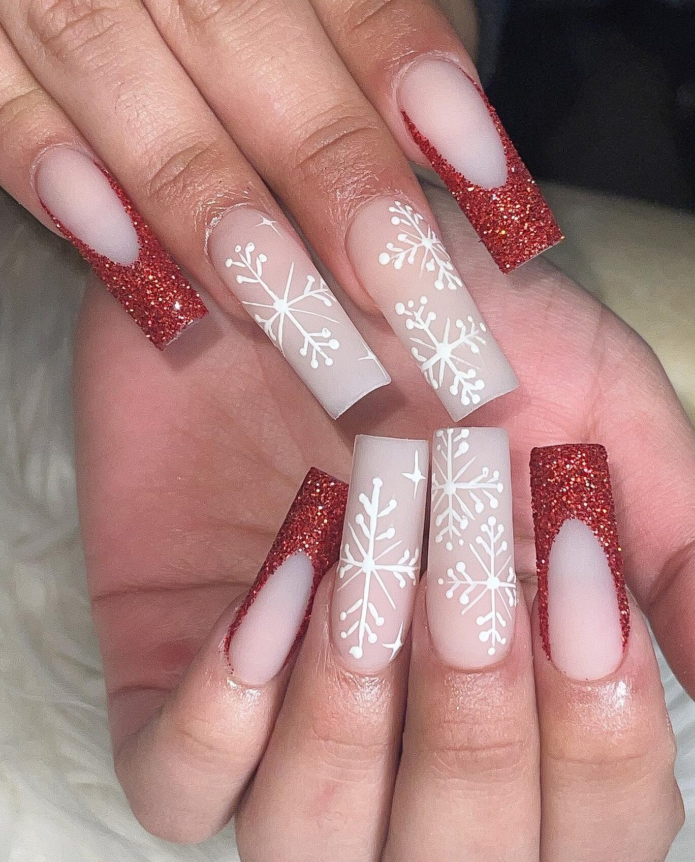 Pointes françaises rouges scintillantes avec des flocons de neige nail art sur des ongles carrés en acrylique super longs