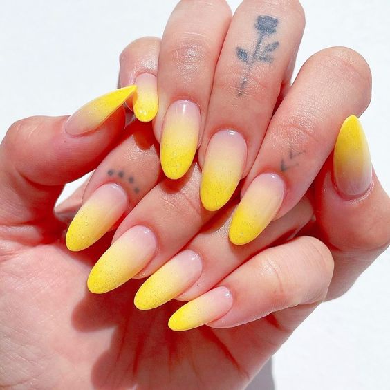 Conception d’ongles ombrés jaune vif sur de longs ongles ronds