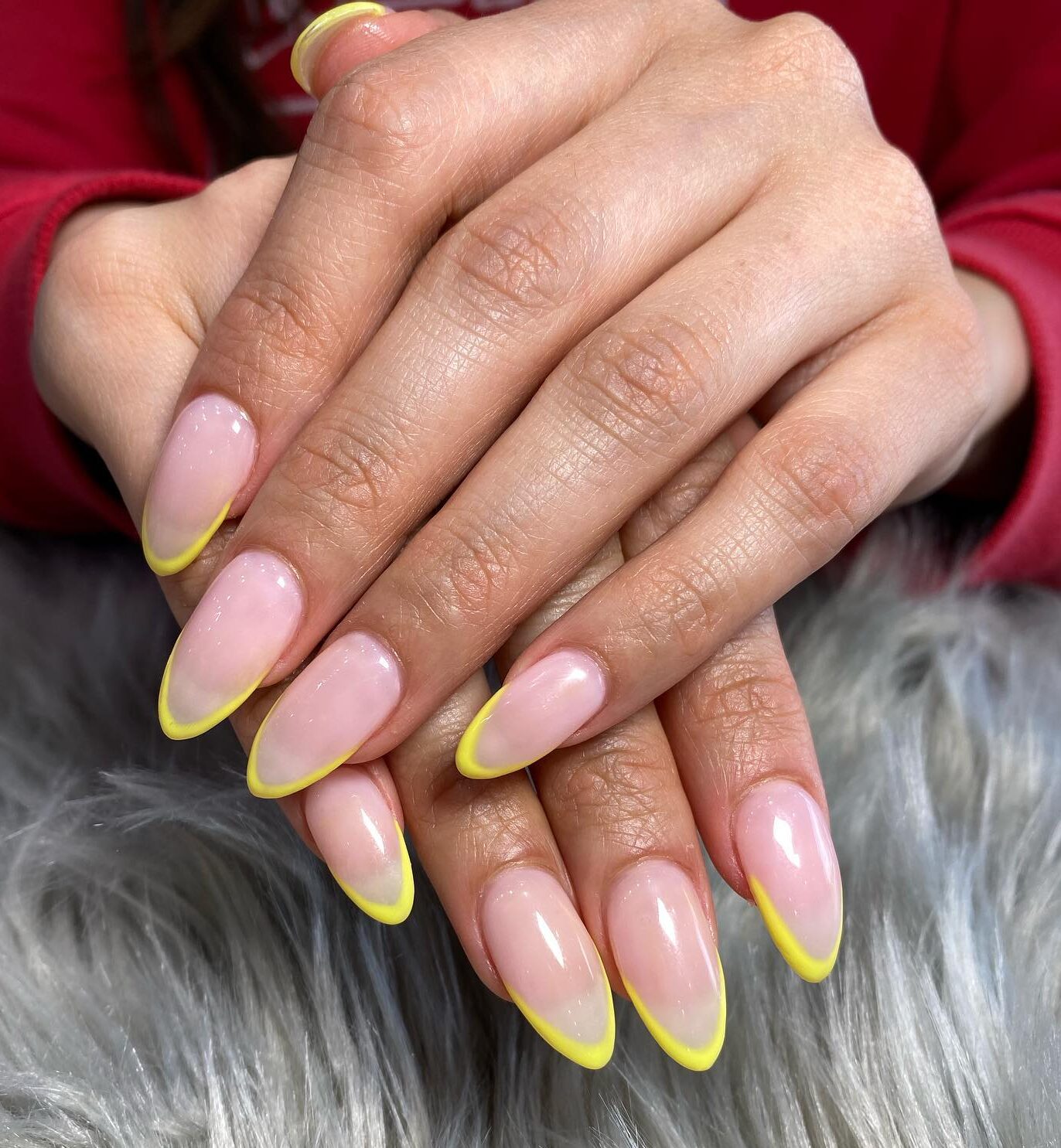 Pointes fines françaises de couleur jaune sur de longs ongles en acrylique en forme d’amande